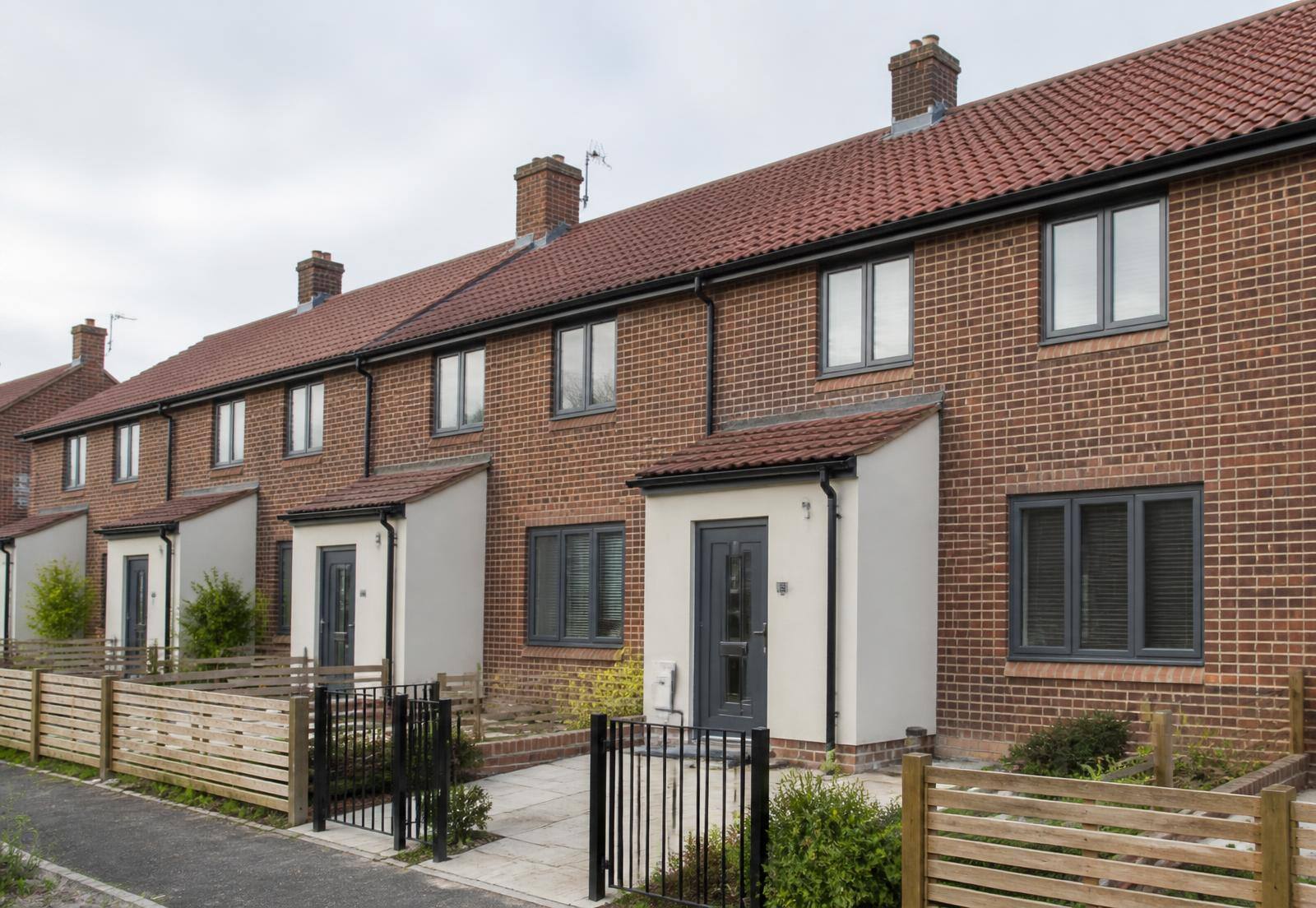 Refurbished brick housing with new windows, roofing and boundary treatment